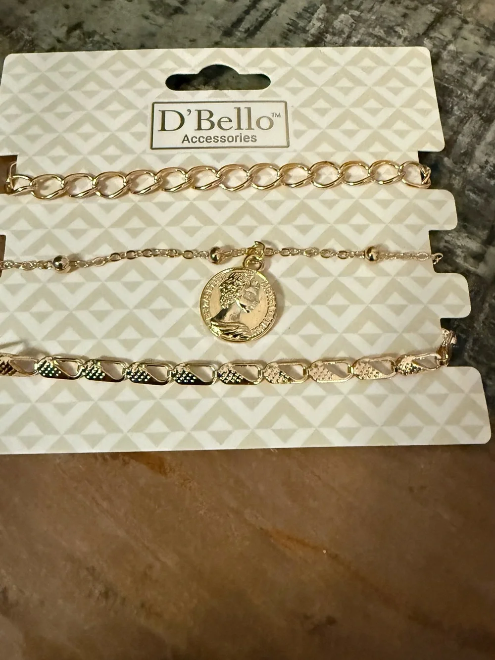 Set of 3 D’Bello packaged gold toned bracelets.